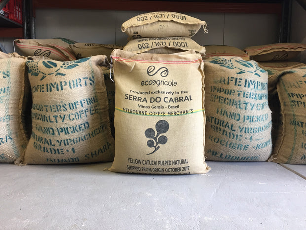 Multiple hessian sacks filled with coffee beans stored in a coffee roasterty.