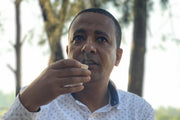Fasysel Yonis holding a warm cup of coffee in Ethiopia.
